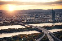 Brücke über einen Fluss mit einer Stadt im Hintergrund, passend zum Thema des Kooperativen Korridormanagements.